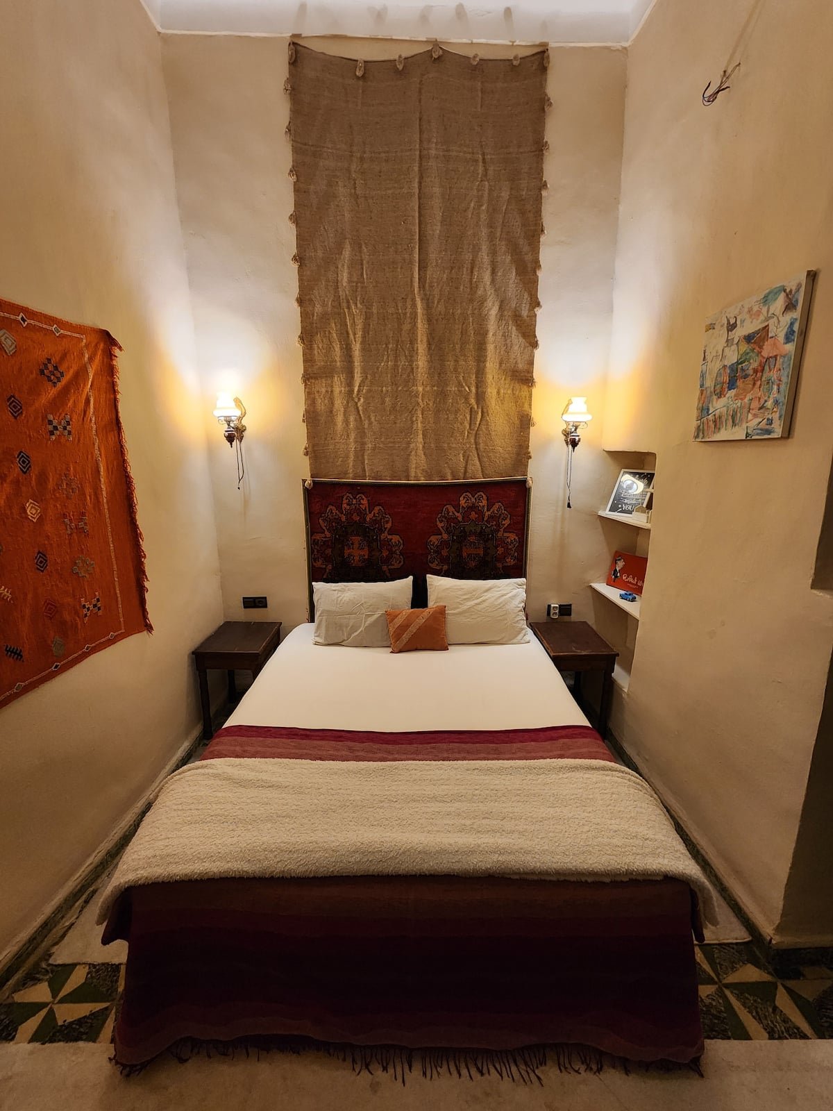 Dar Lala Chafia bedroom with a double bed, Moroccan textiles and warm wall lights