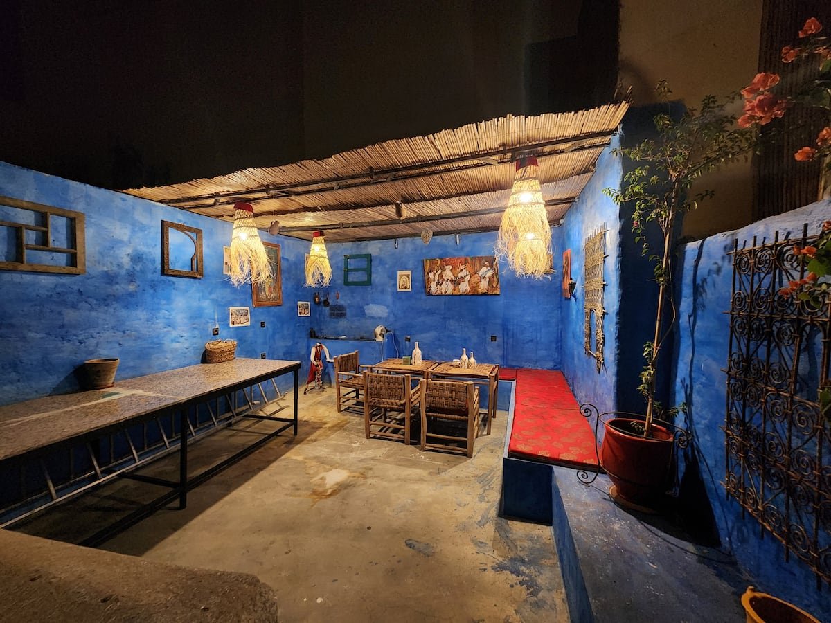 Dar Lala Chafia private terrace with blue walls, woven pendant lights and a dining table