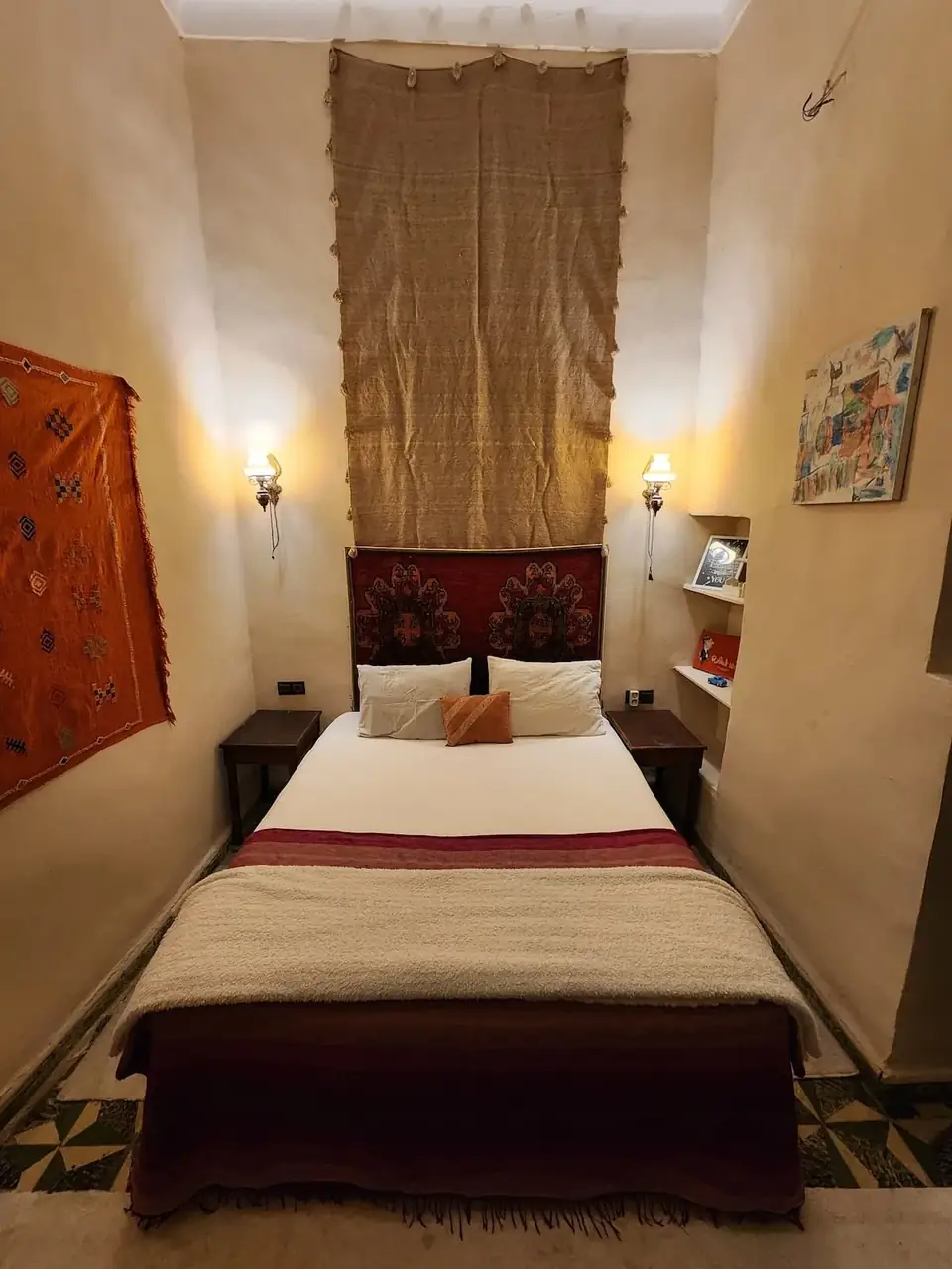 Dar Lala Chafia bedroom with a double bed, Moroccan textiles and warm wall lights
