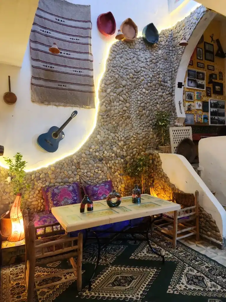 Dar Lala Chafia stone patio with Moroccan seating and a blue guitar